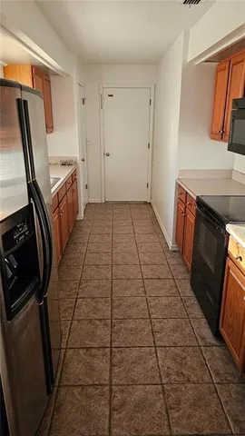 a view of an empty room with wooden floor and a fireplace