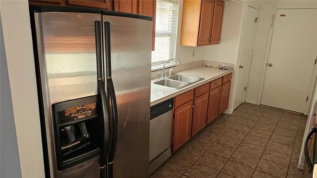 a kitchen with granite countertop a refrigerator and a sink