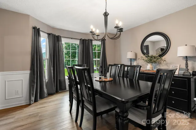 a view of a dining room with furniture a chandelier and wooden floor