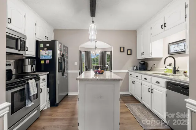 a kitchen with stainless steel appliances granite countertop a stove and cabinets