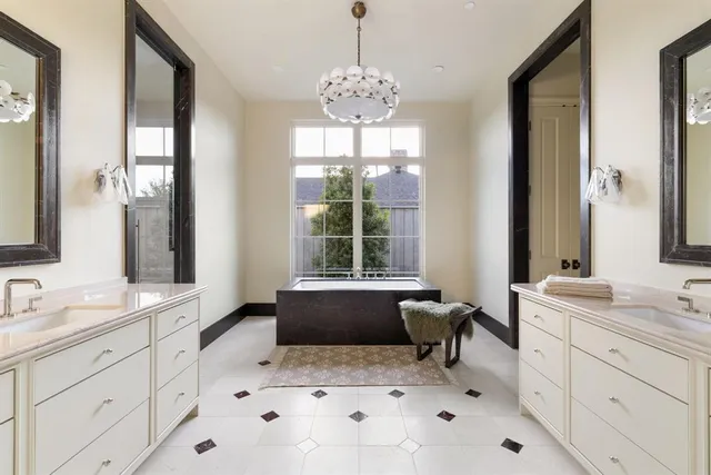 a spacious bathroom with a granite countertop sink vanity mirror bathtub and next to a window