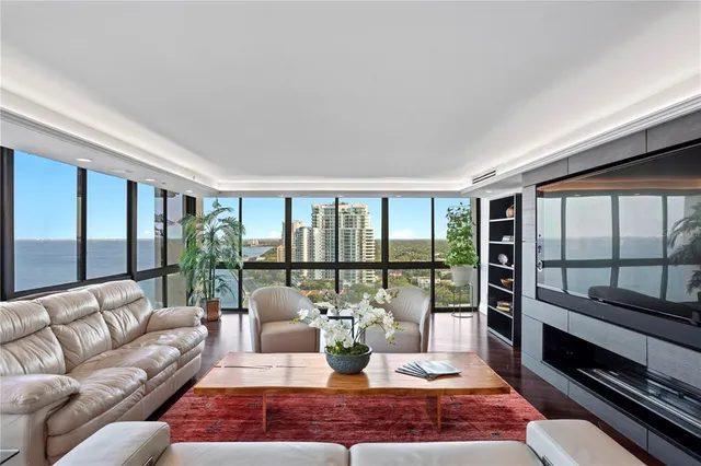 a living room with furniture kitchen view and a large window