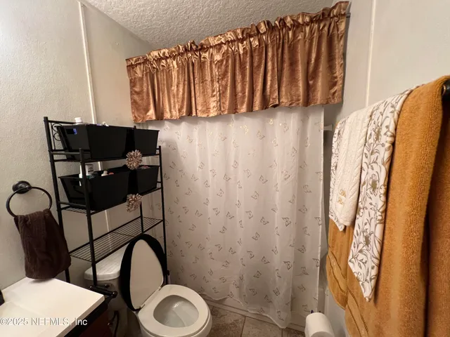 a spacious bedroom with a bed and a chandelier