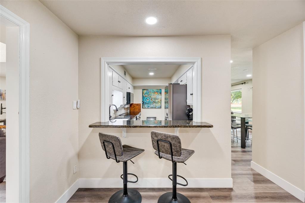 61 1 Main Place Benbrook, TX 76126 - Photo 14 of 21 a view of a kitchen with dining area a chandelier a wooden table and chairs