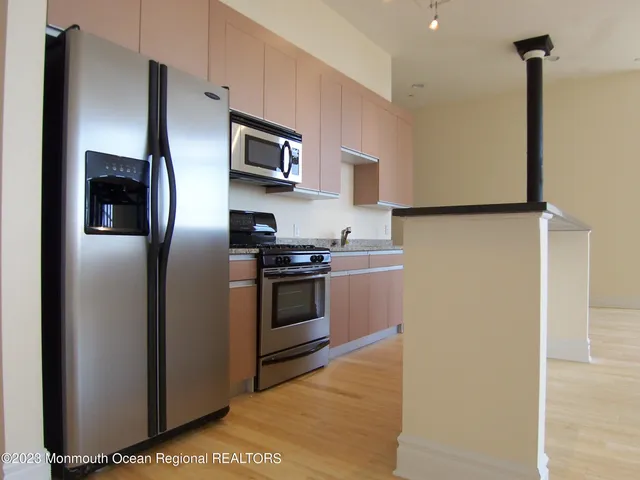 a kitchen with stainless steel appliances a refrigerator sink and microwave