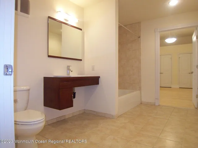 a bathroom with a toilet a sink a mirror and vanity