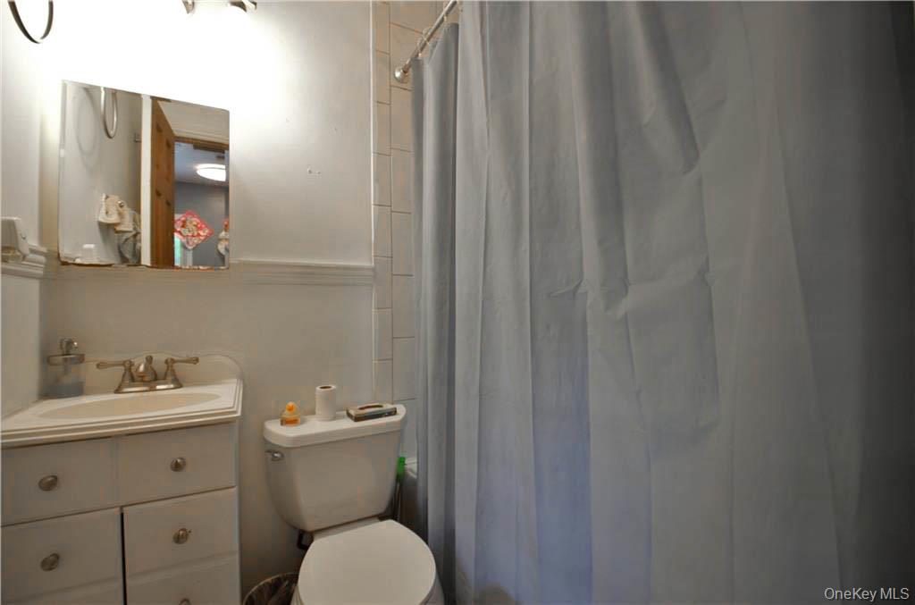 16 Woodland Road Middletown, NY 10940 - Photo 10 of 13 a bathroom with a toilet a sink and mirror