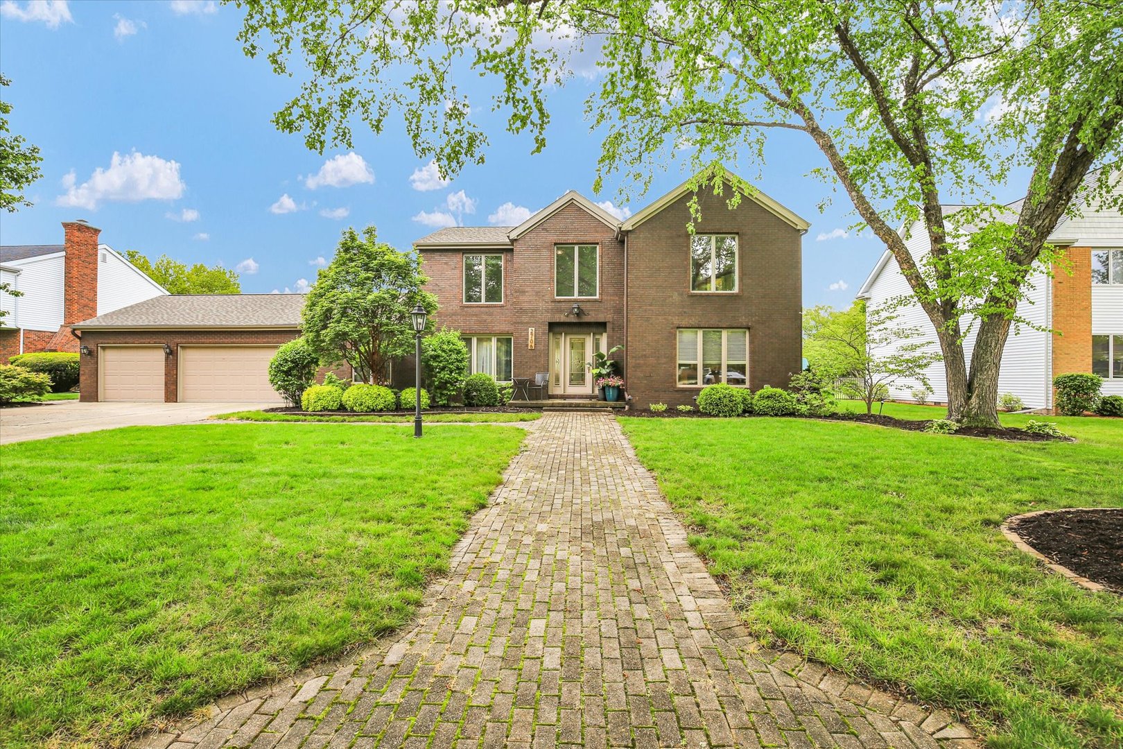 a front view of a house with yard and green space