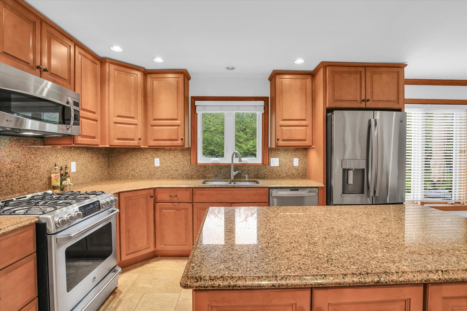 2706 North Salisbury Court Champaign, IL 61821 - Photo 26 of 60 a kitchen with stainless steel appliances granite countertop a stove a sink and a microwave