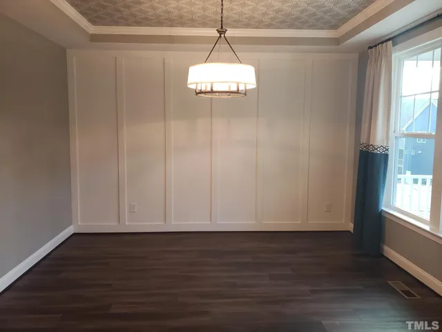 a view of an empty room with wooden floor and a fireplace