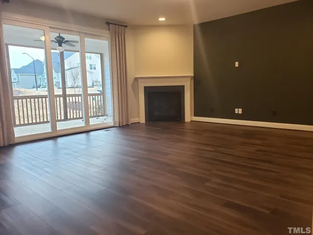 an open kitchen with wooden floor and stainless steel appliances