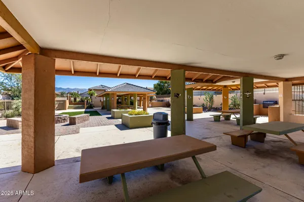 a patio with a table and chairs under an umbrella