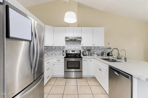 a kitchen with a refrigerator sink and cabinets