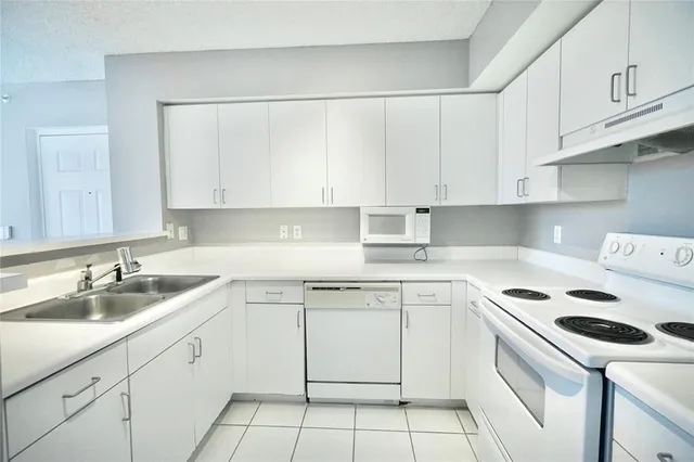 a kitchen with cabinets appliances a sink and a stove