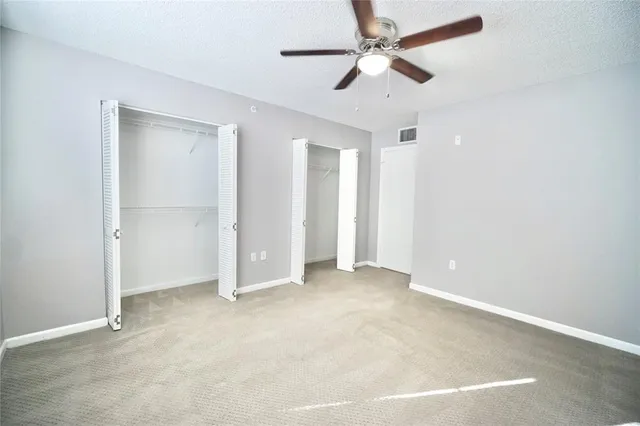 an empty room with chandelier fan