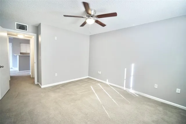 an empty room with closet and a ceiling fan