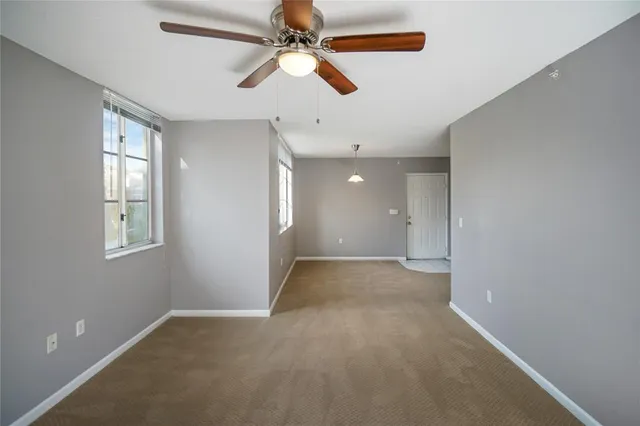 en empty room with windows and fan