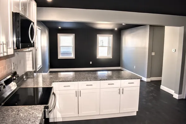 a bathroom with a granite countertop sink a mirror and vanity