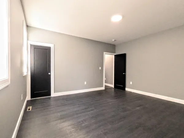 a view of an empty room with wooden floor