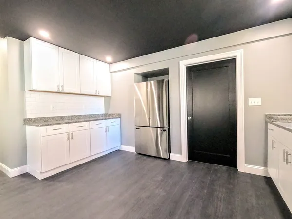 a kitchen with white cabinets and white appliances