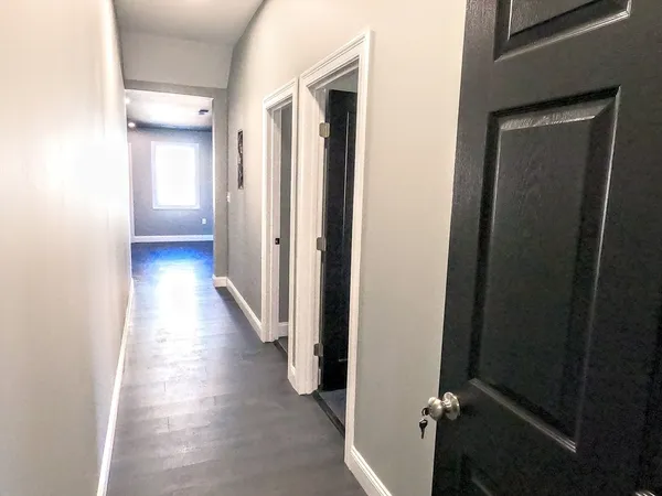 a view of a hallway with wooden floor