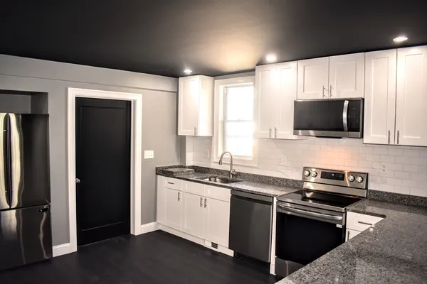 a kitchen with stainless steel appliances a stove a sink and a microwave