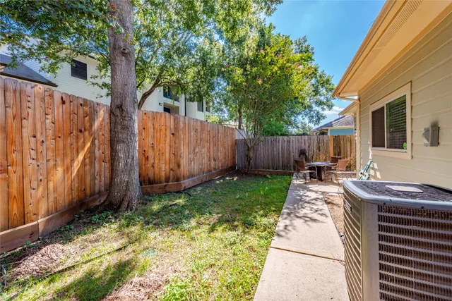 a view of backyard with potted plants and wooden fence