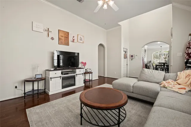 a living room with furniture a flat screen tv and kitchen view