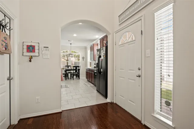 a view of a hallway with wooden floor and a living room