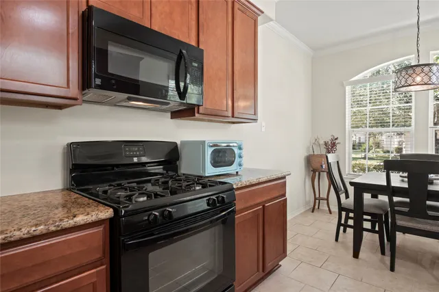 a kitchen with stainless steel appliances a stove a microwave cabinets and a wooden floor