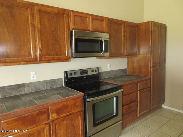 965 Circulo Tumbleweed Rio Rico, AZ 85648 - Photo 5 of 18 a kitchen with stainless steel appliances granite countertop a stove microwave and refrigerator