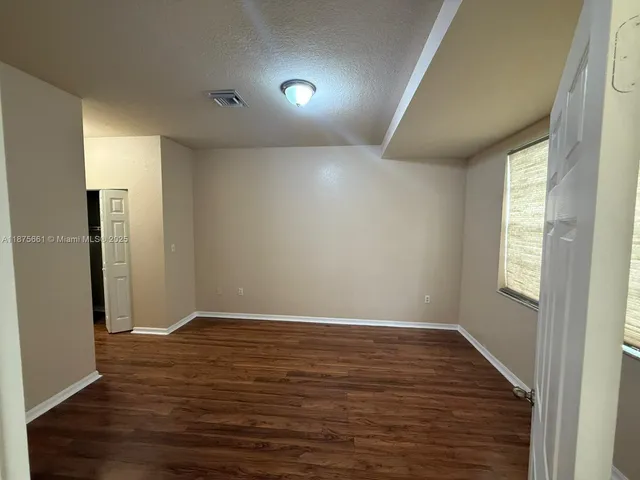 a view of room with window and wooden floor