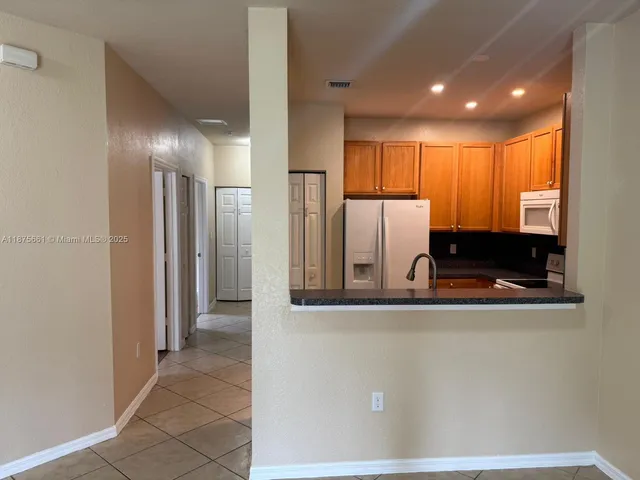 a view of a kitchen with stainless steel appliances granite countertop a refrigerator and a sink