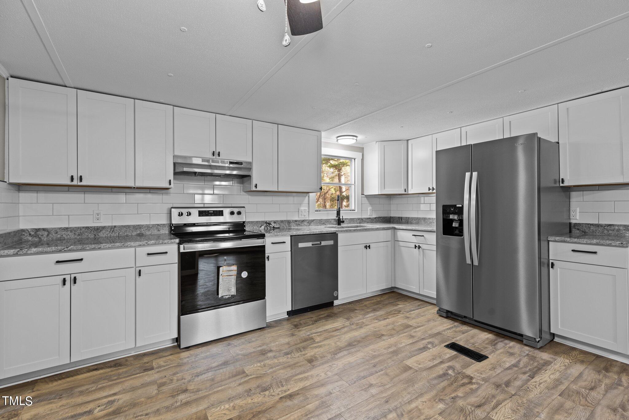 365 Rev Henderson Road Henderson, NC 27537 - Photo 11 of 48 a kitchen with granite countertop white cabinets and stainless steel appliances