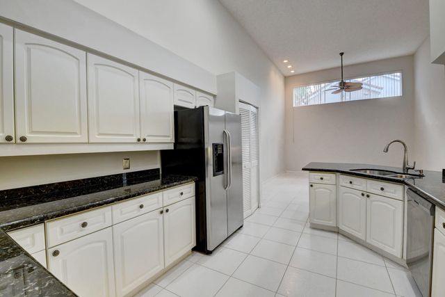 a kitchen with granite countertop white cabinets and stainless steel appliances