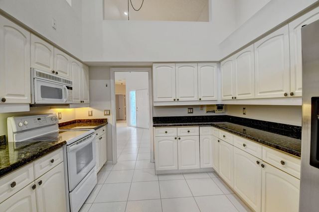 a kitchen with granite countertop white cabinets and stainless steel appliances