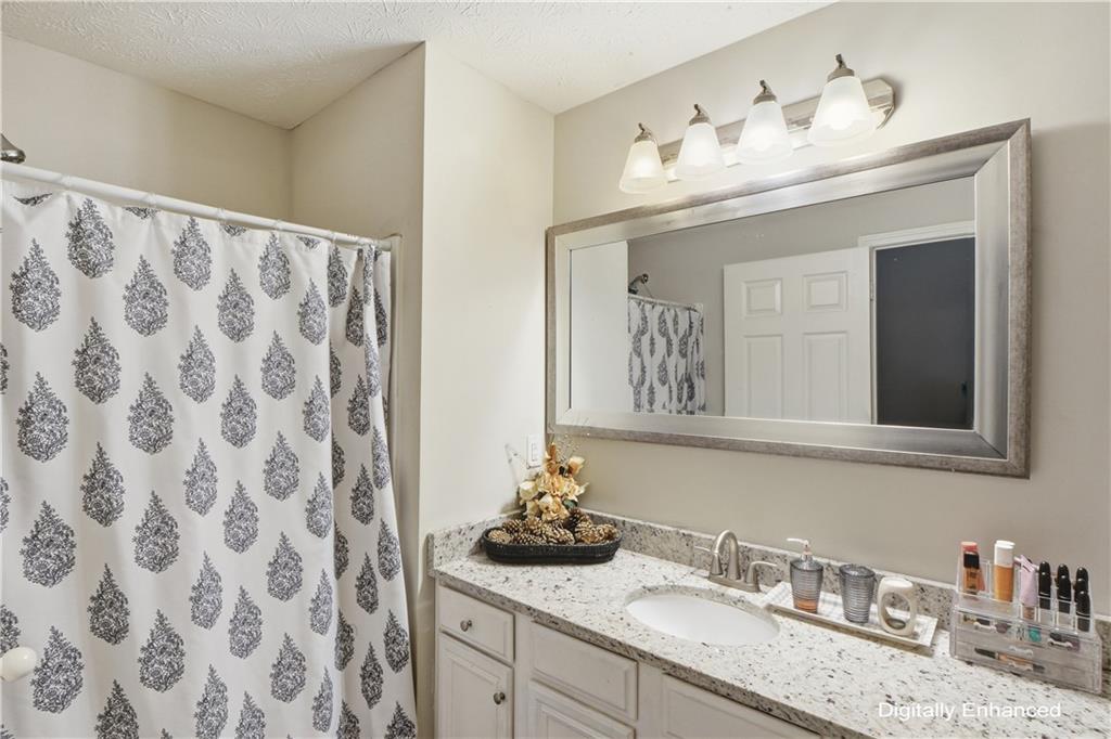 2555 Flat Shoals Road, Unit 2008 Atlanta, GA 30349 - Photo 20 of 33 a bathroom with a granite countertop sink and a mirror