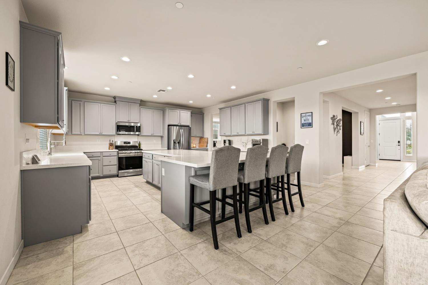 4040 Aura Way Rancho Cordova, CA 95742 - Photo 13 of 49 a kitchen with a dining table chairs and white stainless steel appliances
