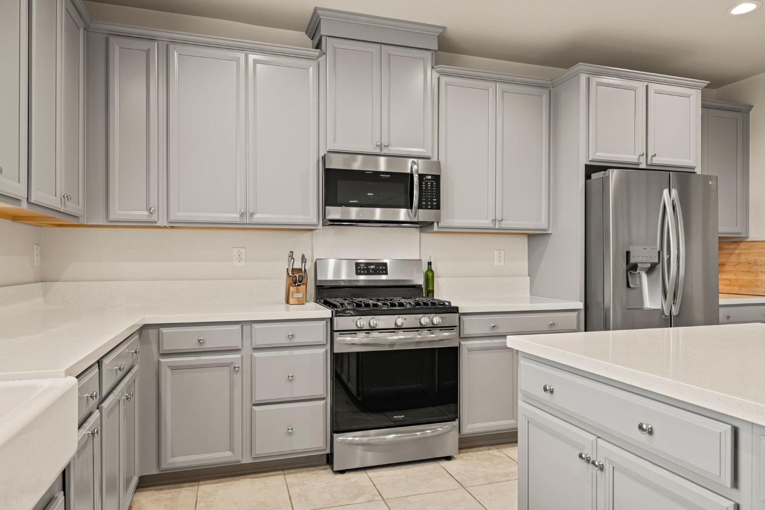 4040 Aura Way Rancho Cordova, CA 95742 - Photo 17 of 49 a kitchen with white cabinets and a stove top oven