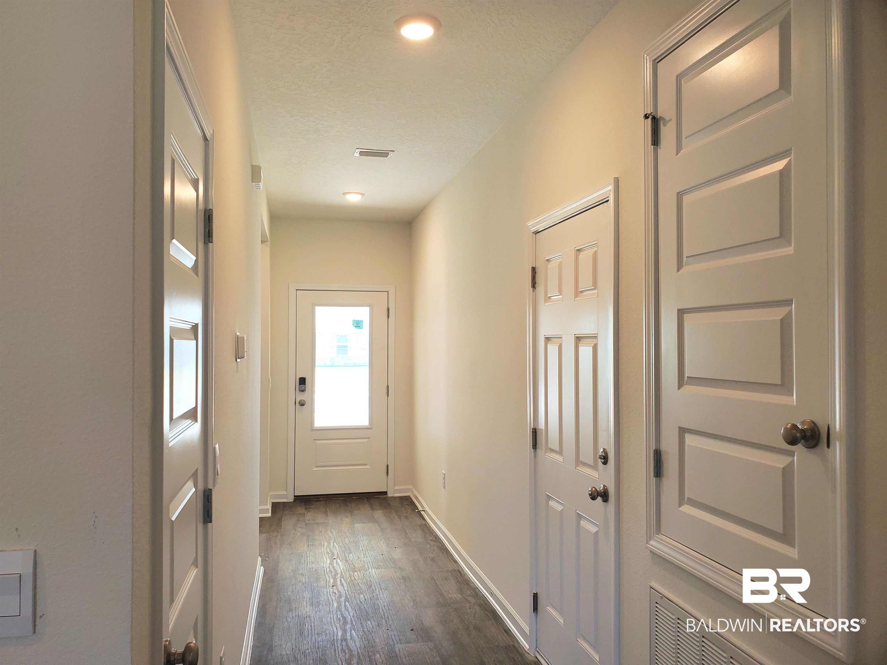 14666 Dayton Circle Foley, AL 36535 - Photo 10 of 21 Doorway to outside featuring a textured ceiling and dark wood-type flooring