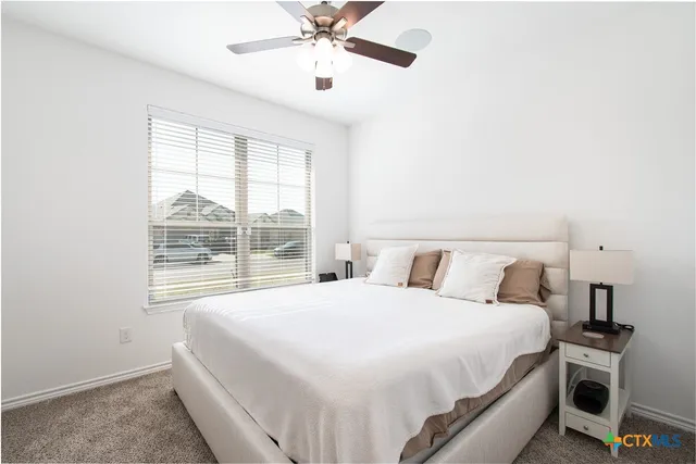 a bedroom with a large bed and a window