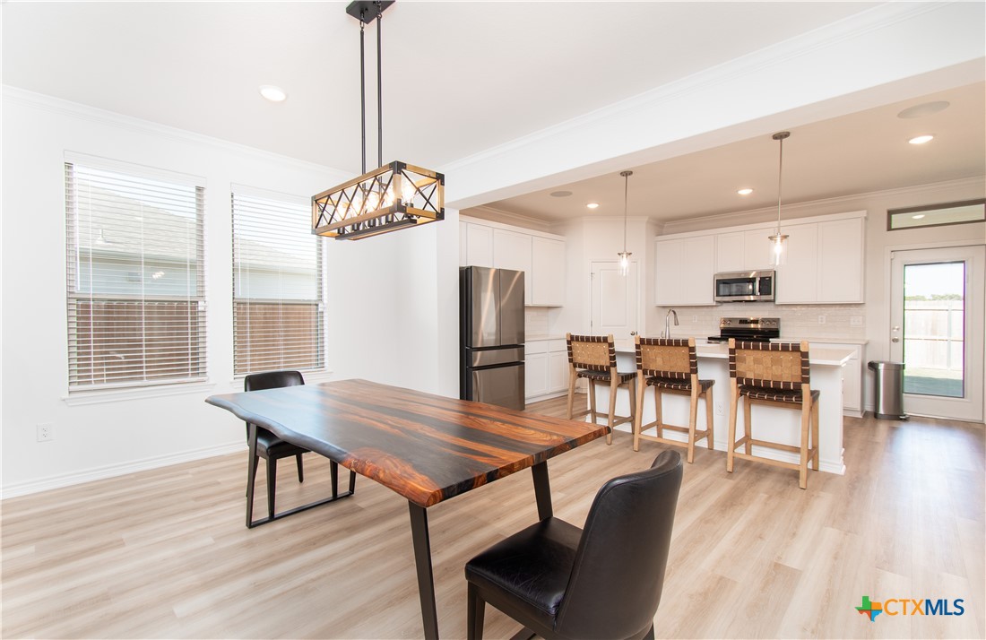 1224 Bending Branch Way Temple, TX 76502 - Photo 6 of 25 a dining room with furniture a chandelier and wooden floor