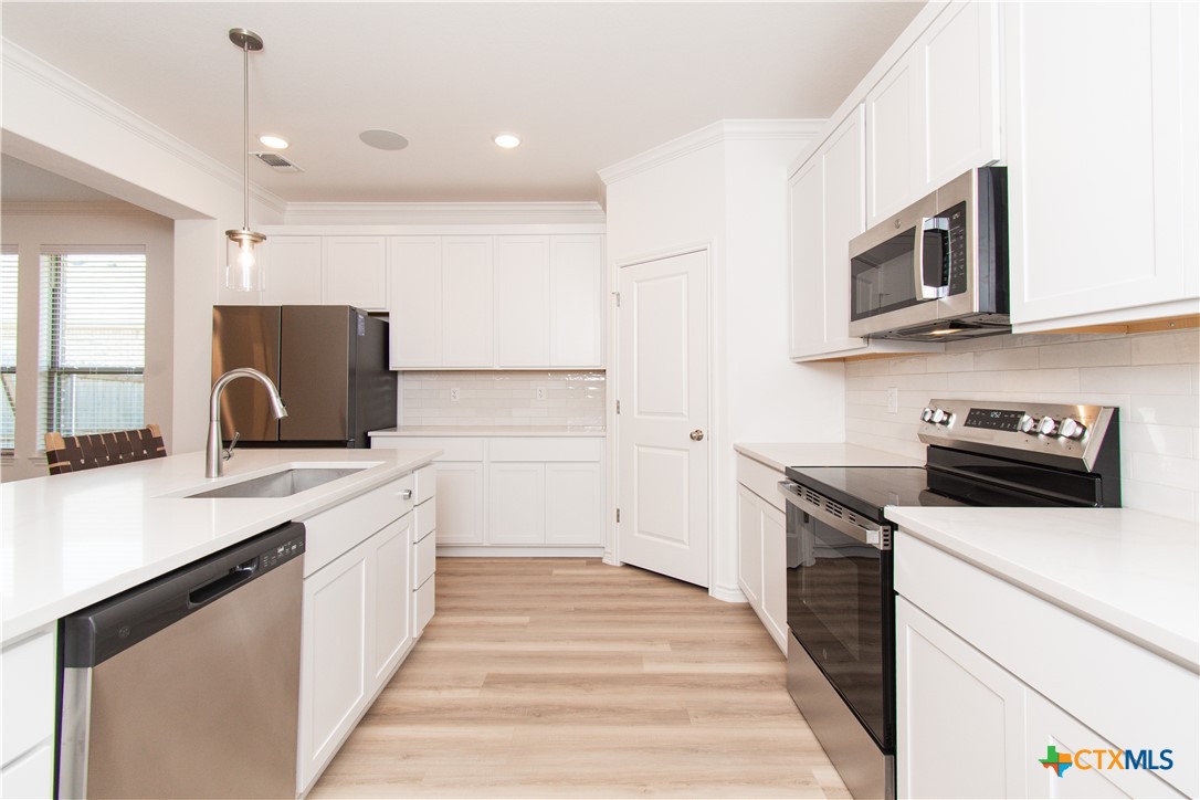 1224 Bending Branch Way Temple, TX 76502 - Photo 8 of 25 a kitchen with stainless steel appliances a stove microwave and sink