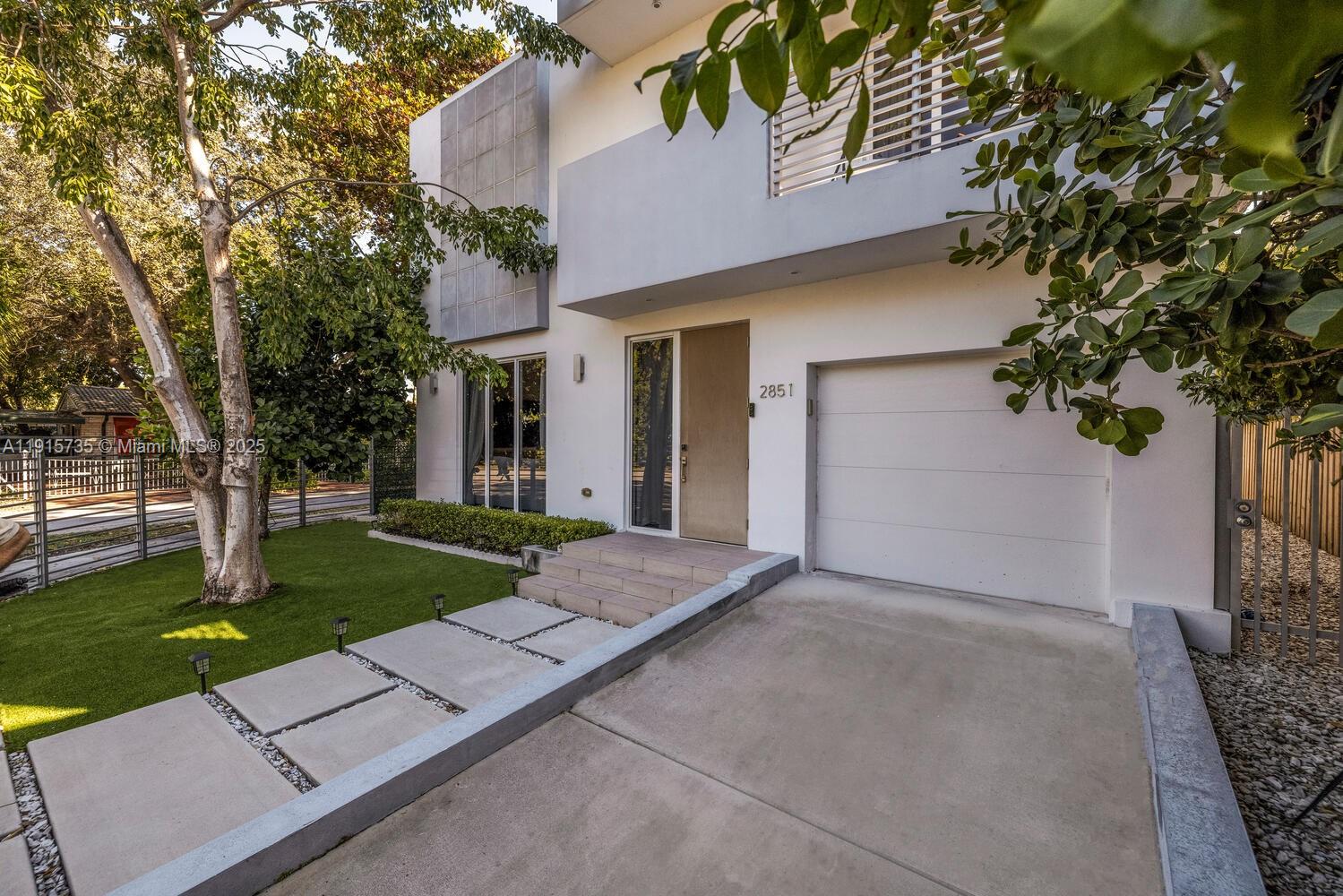 front view of a house with a yard and an trees