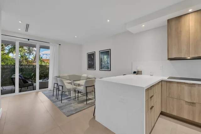 a kitchen that has a sink a table and chairs in it