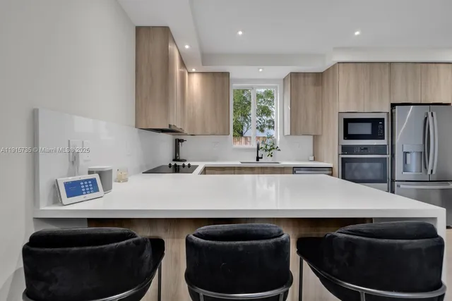 a kitchen with stainless steel appliances granite countertop a sink a stove and a refrigerator