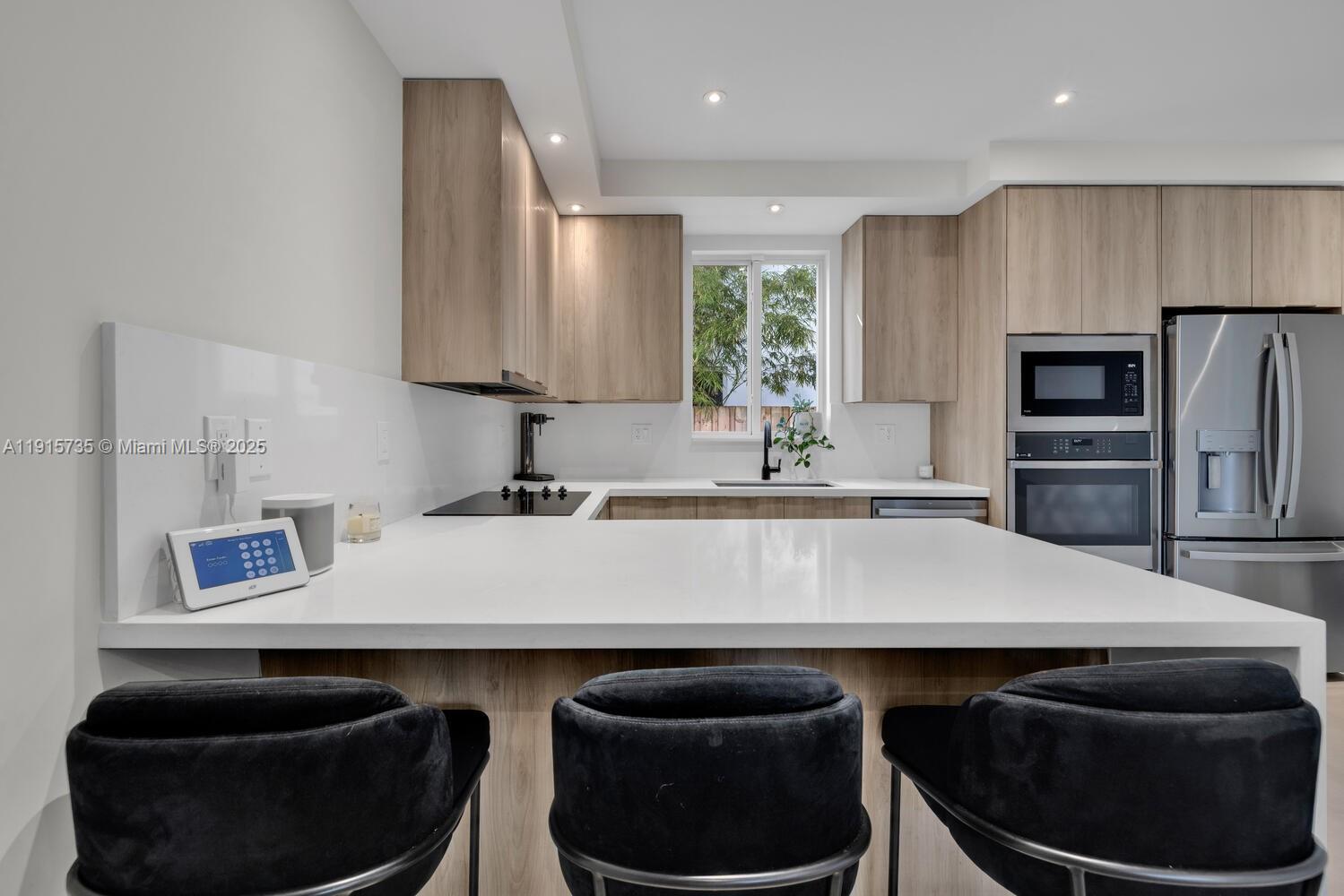2851 Southwest 33rd Court, Unit 2851 Miami, FL 33133 - Photo 27 of 45 a kitchen with stainless steel appliances granite countertop a sink a stove and a refrigerator