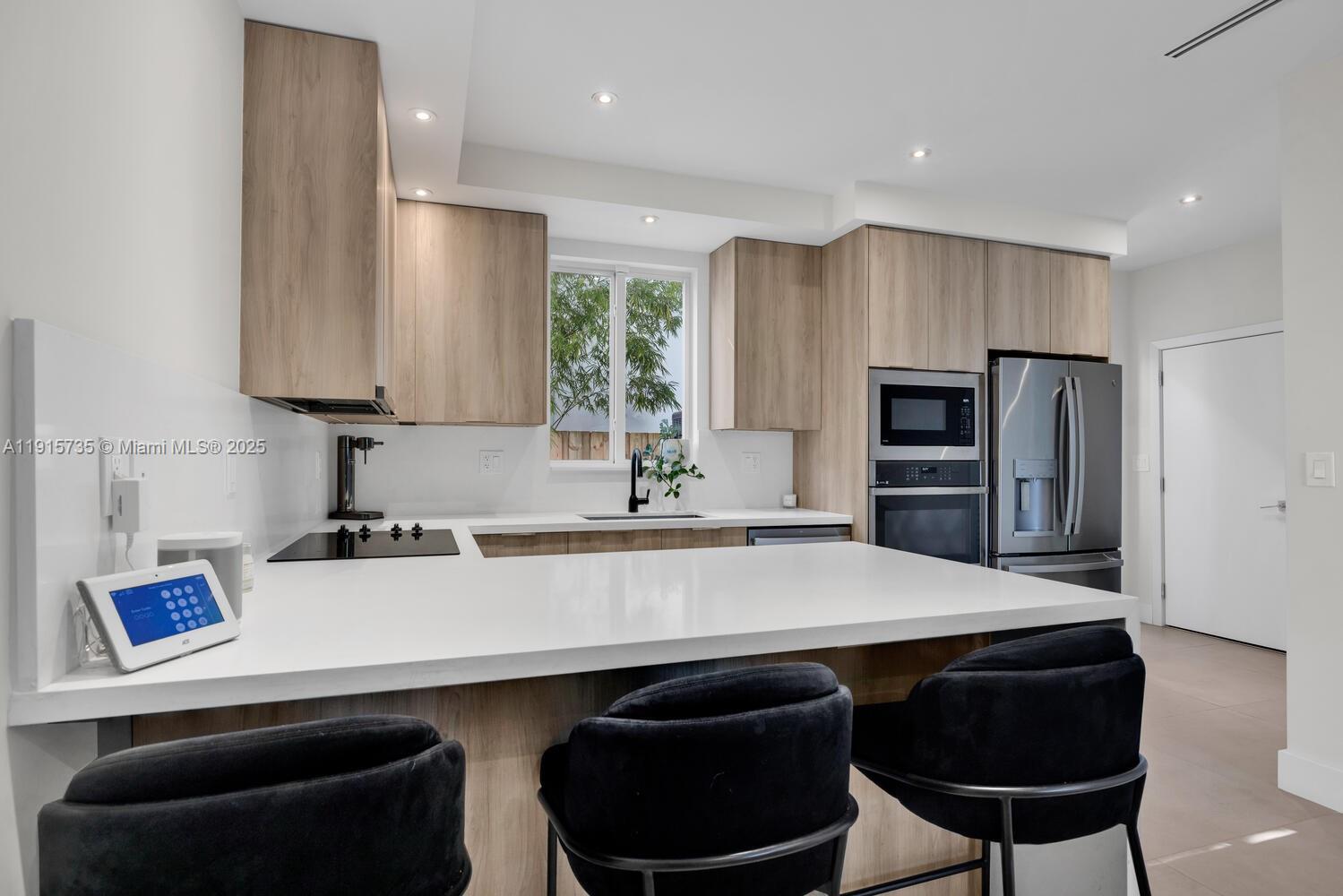 2851 Southwest 33rd Court, Unit 2851 Miami, FL 33133 - Photo 28 of 45 a kitchen with stainless steel appliances a sink dishwasher and a refrigerator with wooden floor