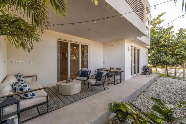 a view of a patio with couple of chairs and potted plants
