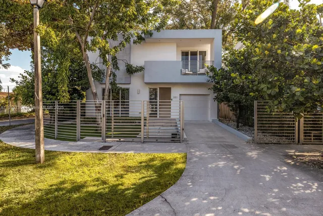 a view of house with backyard and a tree